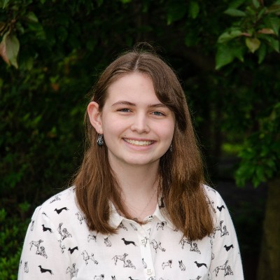 A picture of a young woman with brown hair wearing a white collared shirt
    with dogs on it. Copyright held by Jonathan G Lasley.